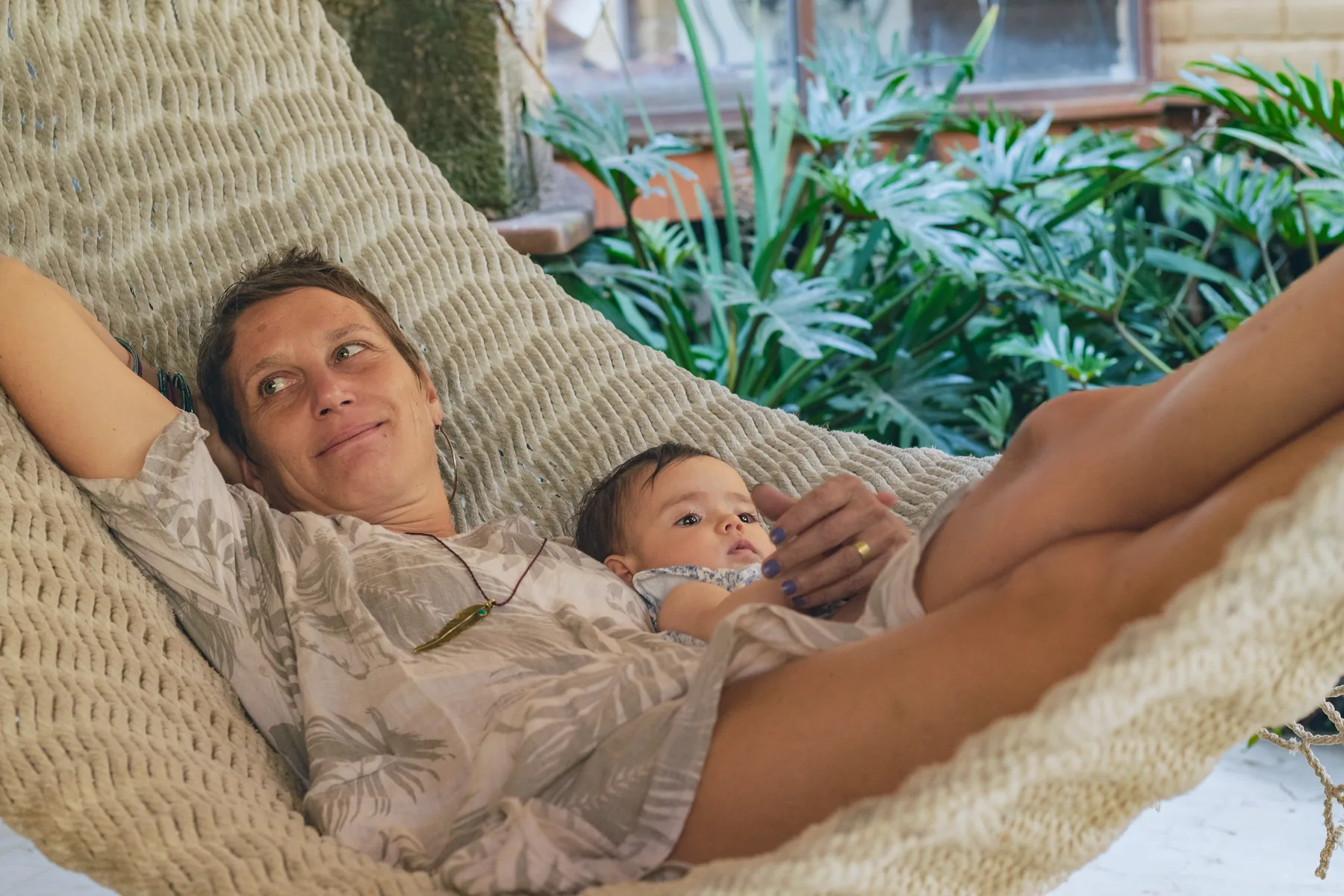 Una madre descansa con su bebé en una hamaca